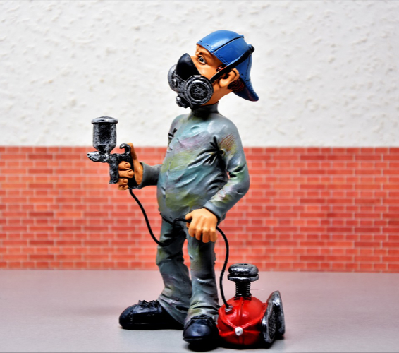 Elektronische Pulver-Beschichtung. Person mit Schutzmaske und Farbspritze.