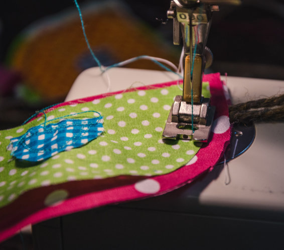 Näherei. Nähmaschine auf der bunte Stoffe zusammengenäht werden.