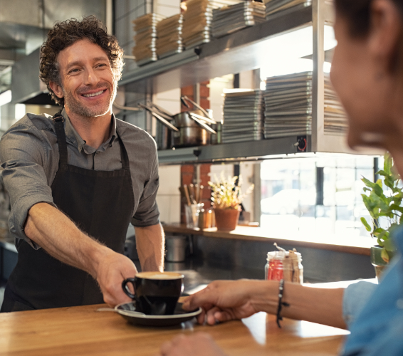 Kundenkontakt. Person übergibt Kaffee an einen Kunden
