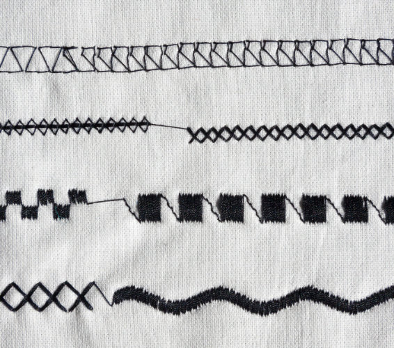 Grundlagen Textil. Verschiedene Näh-Stich-Arten auf einem Stück Stoff.