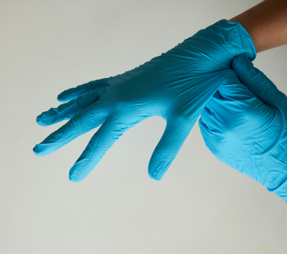 Arbeitssicherheit. Hygiene. Person mit Einmalhandschuhen.