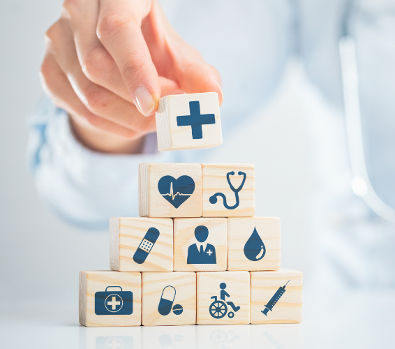 Betriebliches Gesundheitsmanagement. Würfel mit medizinischen Symbolen werden übereinander gestapelt.