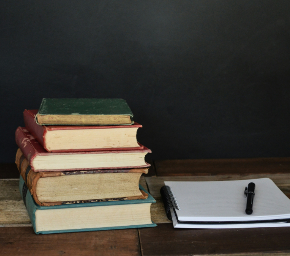Grundbildung. Bücherstapel und Notizblock.