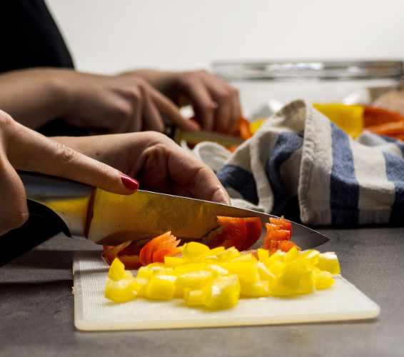 Nahrungsmittel zerkleinern. Person schneidet Paprika.