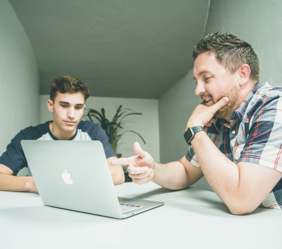Zwei Personen vor einem Laptop.