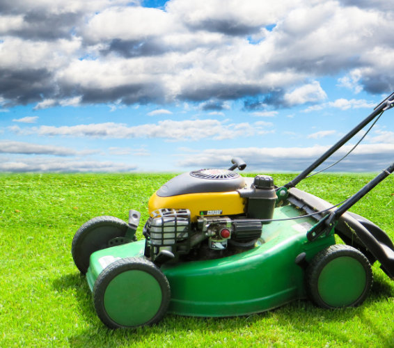 Rasenmäher auf Gras mit prächtigem Himmerl im Hintergrund