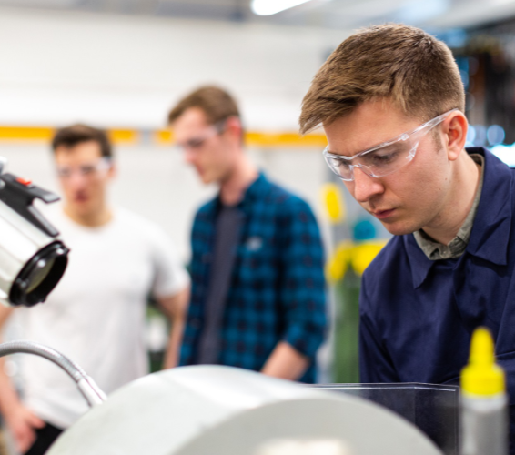 Praktikum. Junge Menschen mit Schutzbrille am Arbeitsplatz.