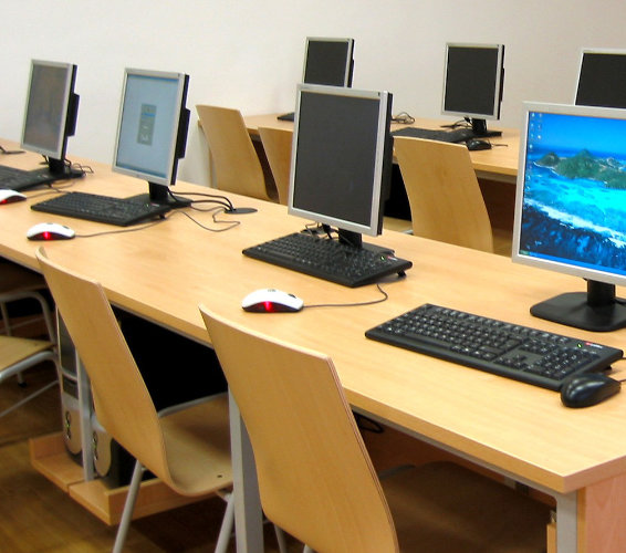 Einführung in die EDV. Computerraum. Viele Tische mit Bildschirmen und Tastatur.