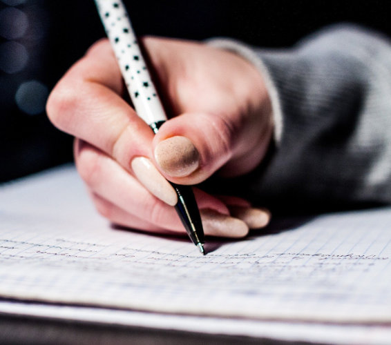 Schreiben: HAnd mit STift, die auf PApier schreibt