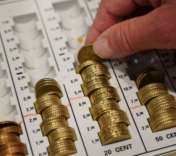 Geld. Kleingeld wird einsortiert.