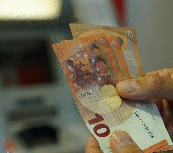Geld abheben: EIne Hand mit 10-Euro-Scheinen aufgefächert