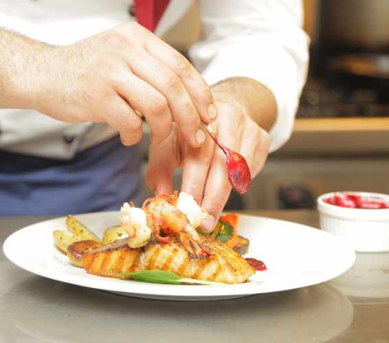 Verkauf und Gastronomie. Teller mit Essen wird angerichtet.